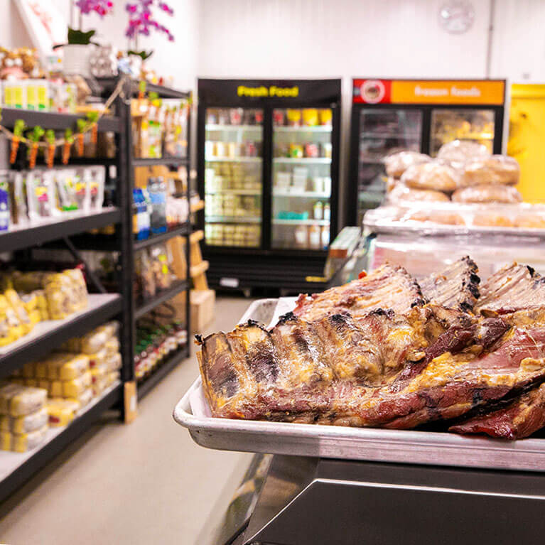 Grilled ribs displayed in grocery store section