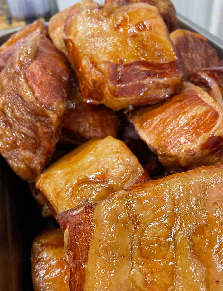 Smoked pork pieces in metal tray