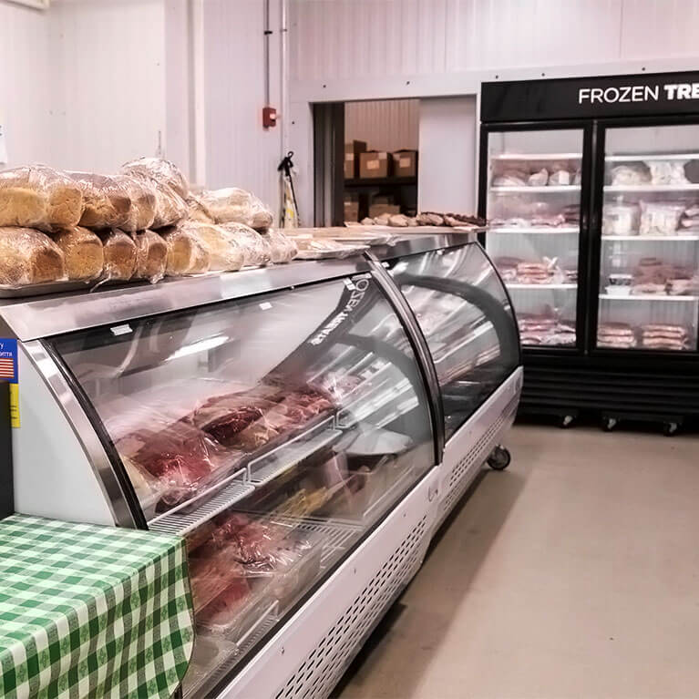 Butcher shop display with meats and frozen goods