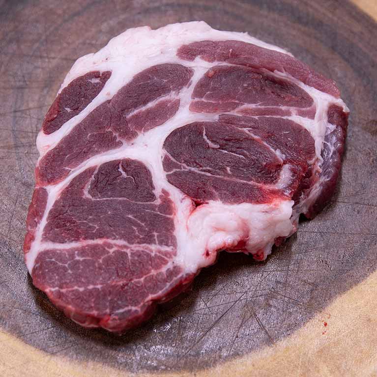 Raw beef steak on wooden cutting board
