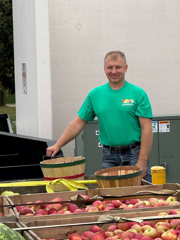 Man selling apples at outdoor market stand