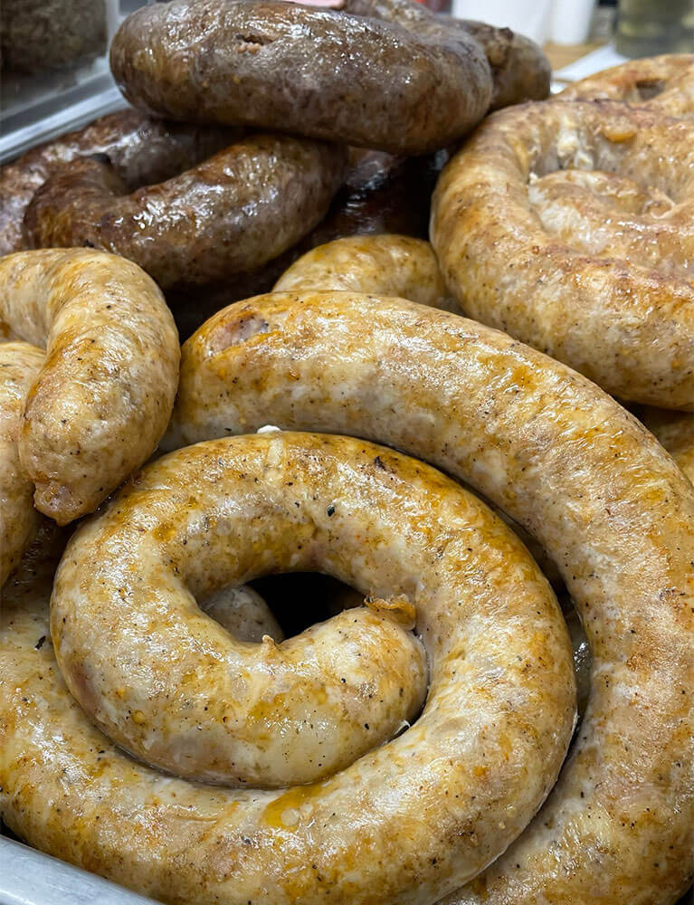 Freshly cooked coiled sausages on display tray